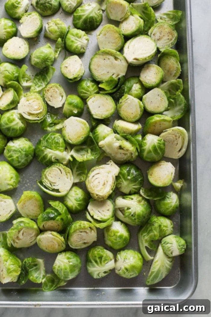 Roasted Brussels Sprouts with Crispy Bacon 4 Halved and seasoned Brussels sprouts spread in a single layer on a baking sheet.
