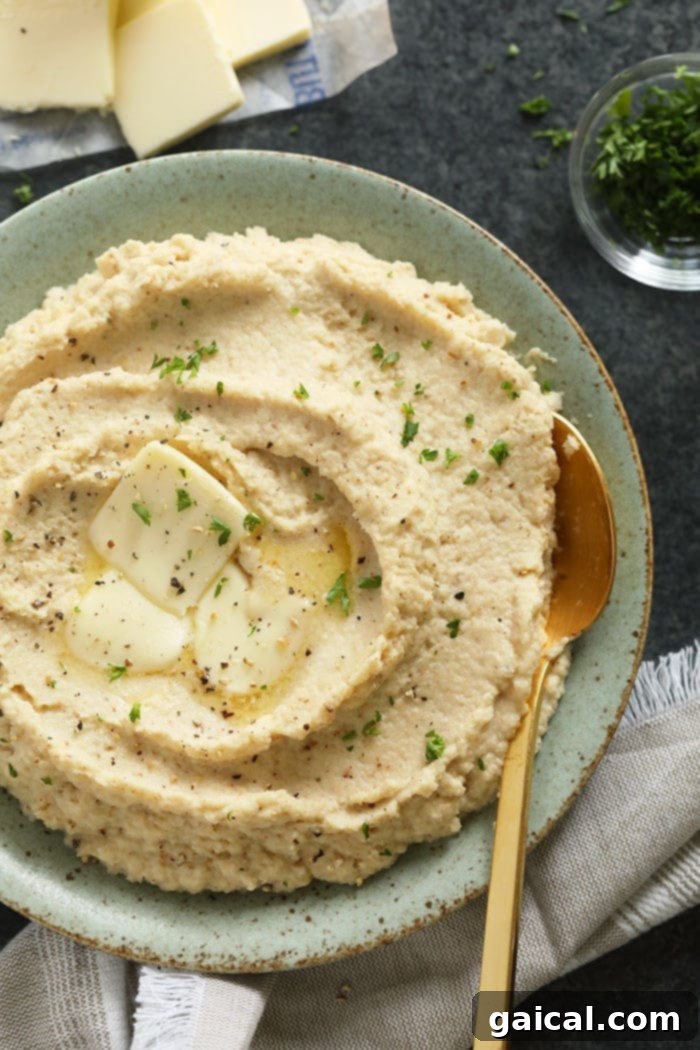 Make these cauliflower mashed potatoes for your next dinner party! They make a great low carb side dish for the holidays! Not only are they healthy, but they are insanely delicious! Cauliflower mashed potatoes in a bowl, garnished with herbs.