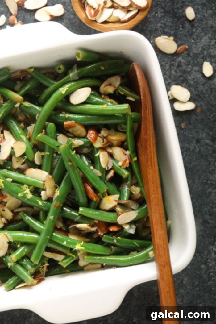 Green Beans with Toasted Almonds 2 A vibrant casserole dish filled with freshly prepared Green Beans Almondine, ready to be served at a holiday feast.