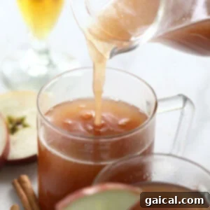 Spiked apple cider being poured into a cozy mug, ready to be enjoyed.