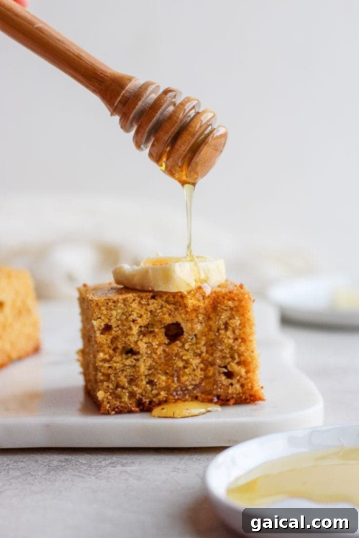 The most flavorful Skillet Cornbread made healthier with finely-ground cornmeal, white whole wheat flour, honey, and coconut oil. Warm cornbread in a skillet topped with melting butter and a drizzle of honey.