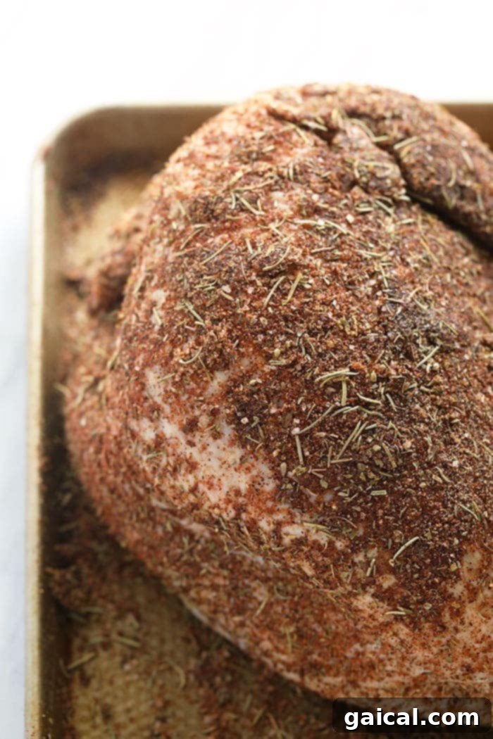 Ditch the store-bought turkey seasoning and use the most Flavorful Turkey Seasoning made with 9 ingredients you can actually pronounce. Winner winner, turkey dinner! A raw turkey, generously coated with a rich, aromatic homemade turkey seasoning, ready for roasting to golden perfection.