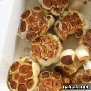 Garlic bulbs roasting in the oven, showing slight browning.