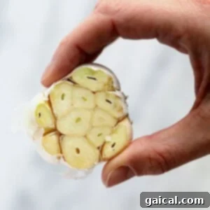A garlic bulb with its top trimmed, showing exposed cloves.