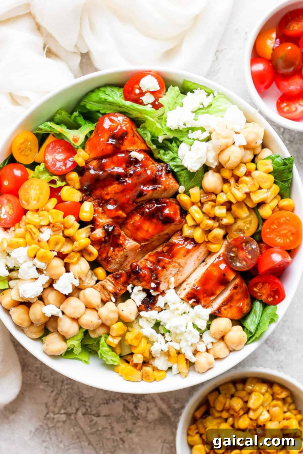 Grilled BBQ Chicken Salad 2 A vibrant BBQ chicken salad featuring corn, cherry tomatoes, and garbanzo beans, dressed in a creamy sauce.