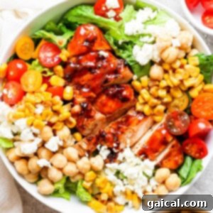 Grilled BBQ Chicken Salad 7 A bowl of BBQ chicken salad with chickpeas and tomatoes, ready to eat.