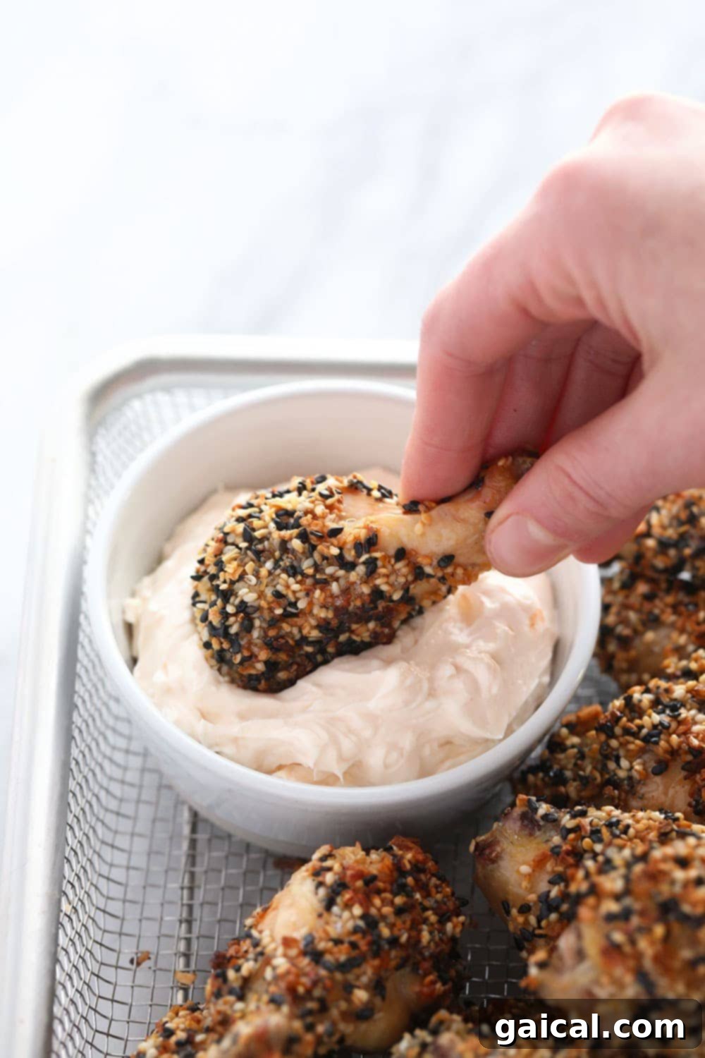 Everything Bagel Seasoning Wings with Cream Cheese Dip Dipping a crispy baked chicken wing into a creamy dip