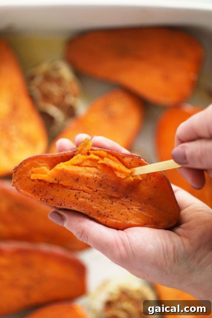 Serve these healthy mashed sweet potatoes at your next holiday gathering or make it as a side next to any of your favorite entrees. A spoon scooping out the soft, cooked flesh from a roasted sweet potato half.