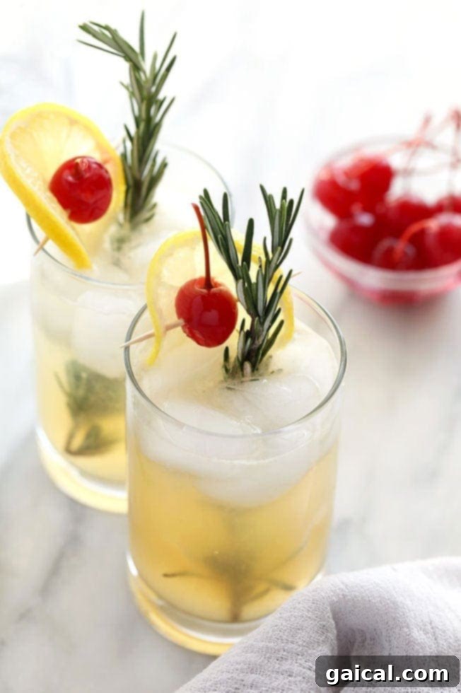Rosemary Vodka Collins A stylish Rosemary Vodka Collins cocktail in a tall glass, garnished with a fresh rosemary sprig and lemon slice.