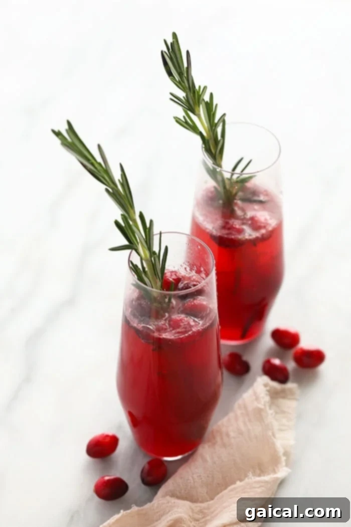 Thanksgiving Harvest Libations 4 Vibrant Cranberry Mojitos in glasses, garnished with fresh cranberries and mint, showcasing their festive appeal.
