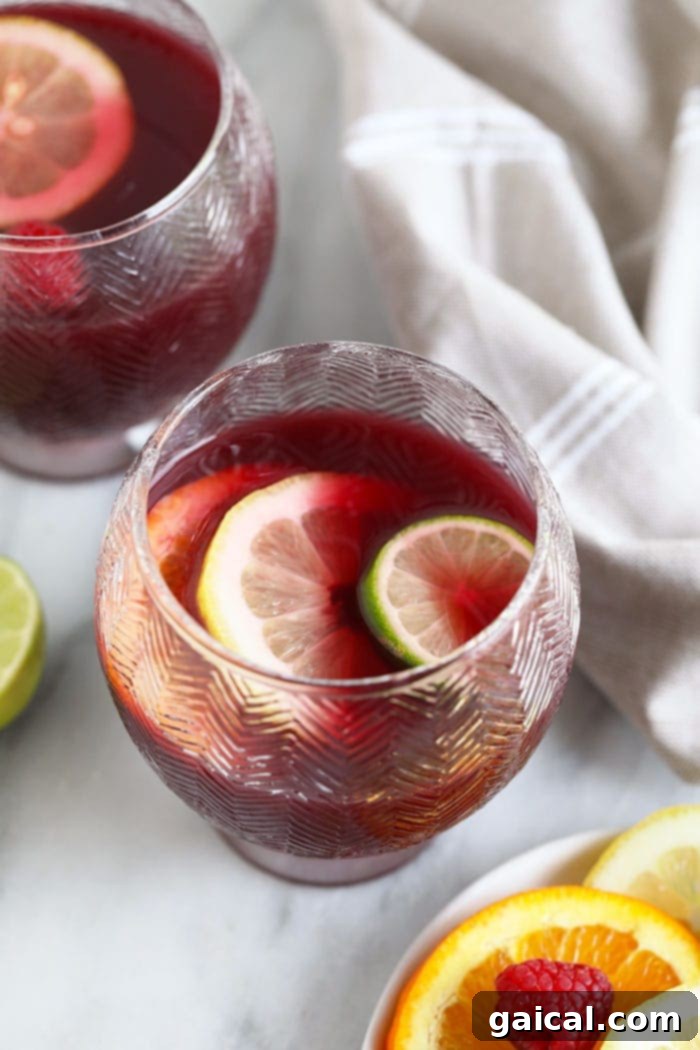 Easy Red Wine Sangria A glass of vibrant red wine sangria, brimming with sliced oranges and other fruits, ready to be enjoyed.