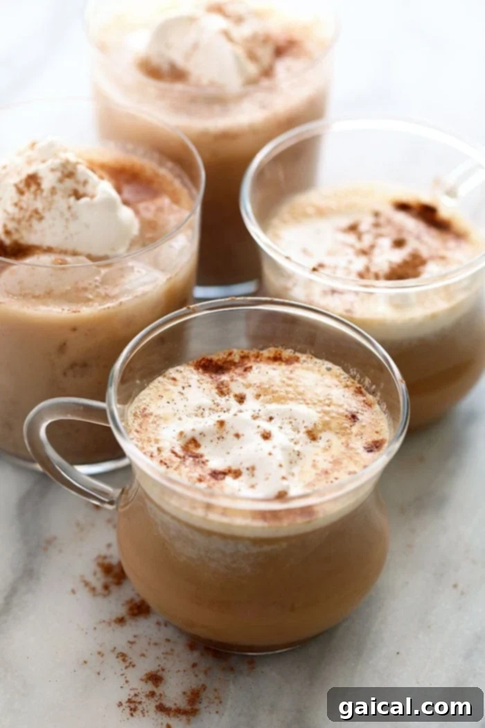 Almond Milk Chai Tea Latte A warm almond milk chai tea latte in a clear glass mug, topped with a sprinkle of cinnamon.