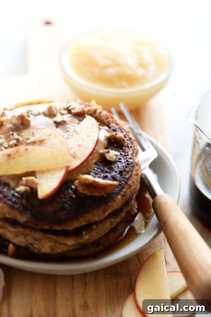 Freshly Made Applesauce Pancakes with Apple Slices A stack of delicious applesauce pancakes, beautifully topped with fresh, thin apple slices, perfectly prepared and ready to be enjoyed as a wholesome meal.