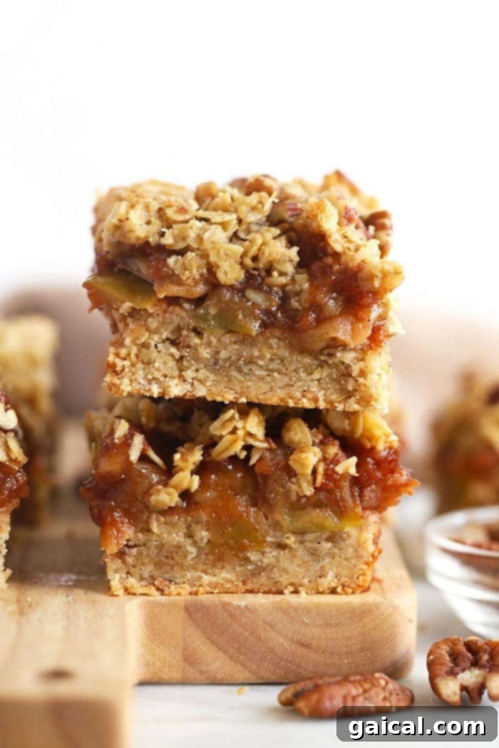 Stacked homemade gluten-free apple pie bars showcasing a rich apple filling and a golden crumble topping, perfect for fall gatherings.