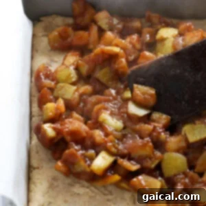An apple pie bar baked on a baking pan, served with a spatula.