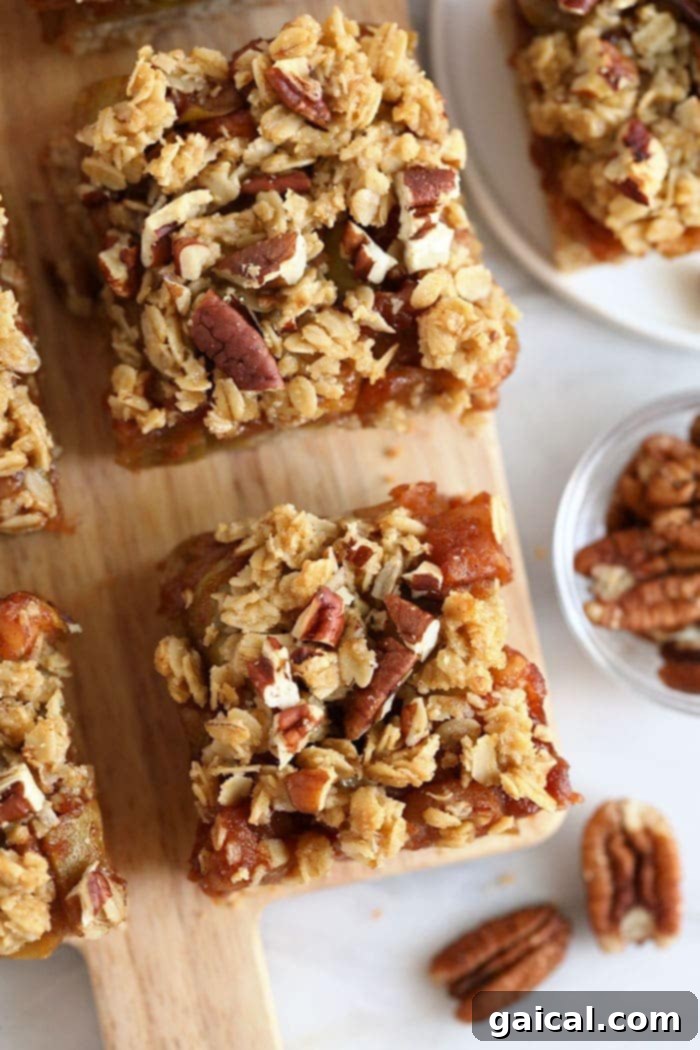 Freshly baked gluten-free apple pie bars, neatly sliced and artfully arranged on a rustic wooden cutting board, ready for serving.