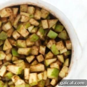 Sliced apples arranged in a white bowl, perfect for making apple pie bars.
