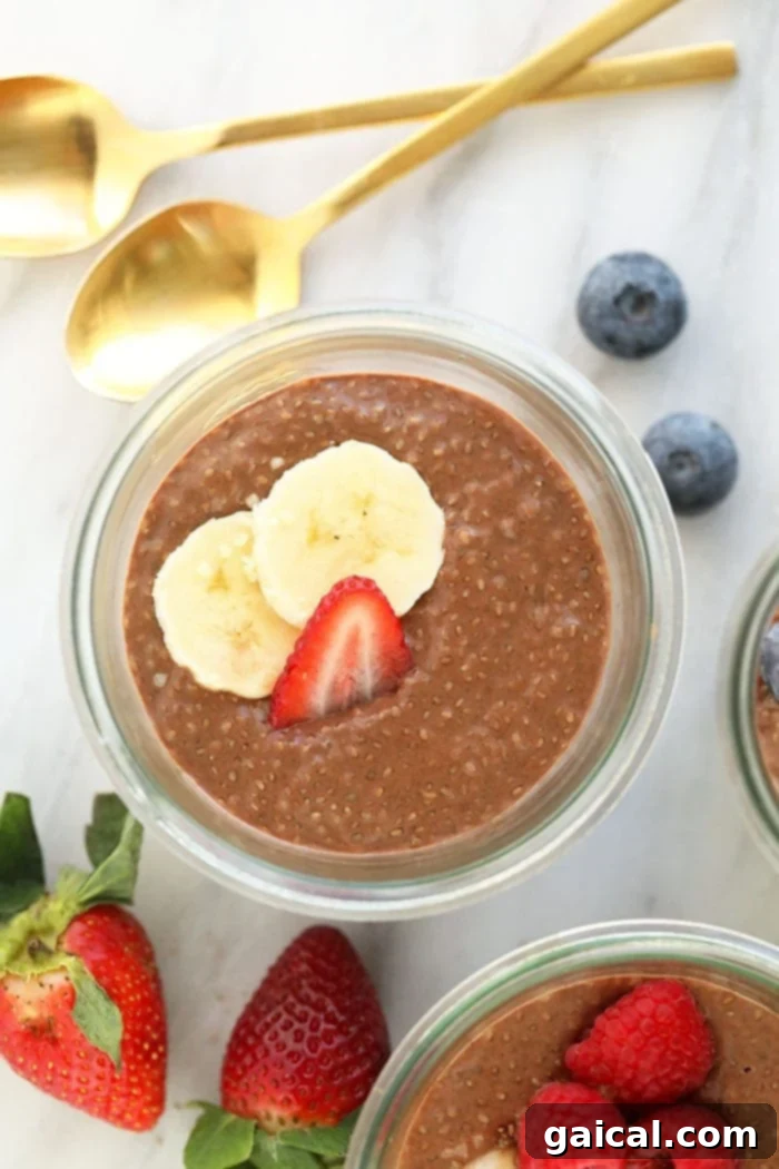 Chia protein pudding in a cup with fresh berries and sliced banana