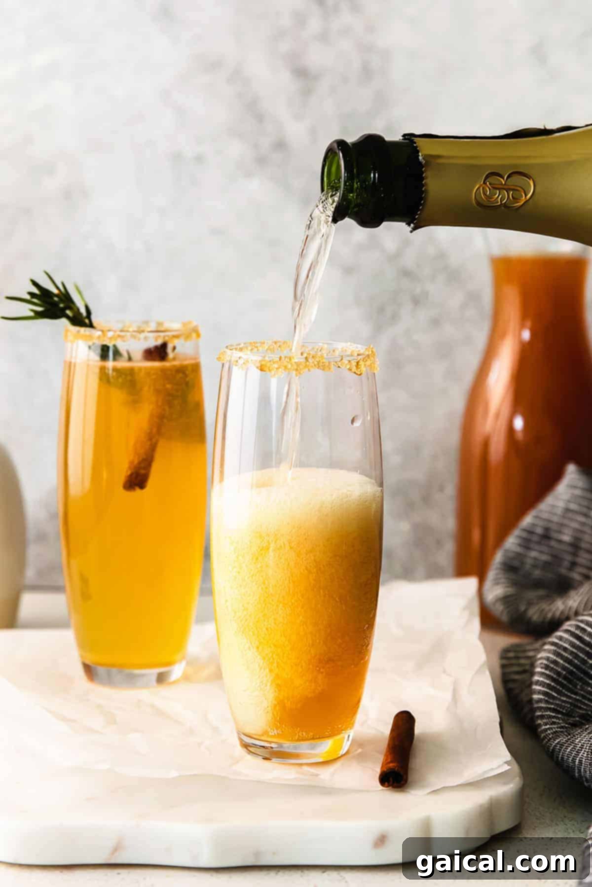 Spiced Apple Mimosa 6 Champagne being expertly poured into a flute already containing apple cider, creating an apple cider mimosa.