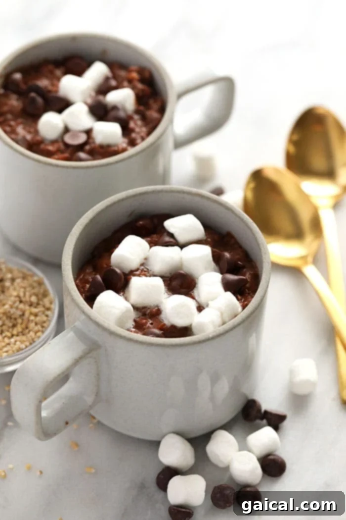 Several mugs of hot cocoa steel cut oats, garnished with marshmallows, ready for serving.