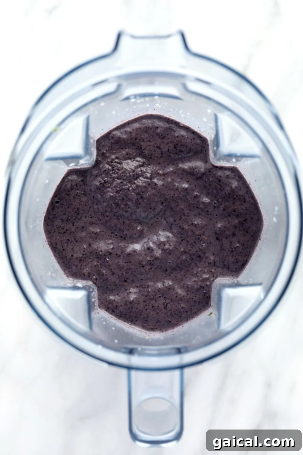 A close-up of a perfectly blended blueberry superfood smoothie, showing its smooth, rich texture.
