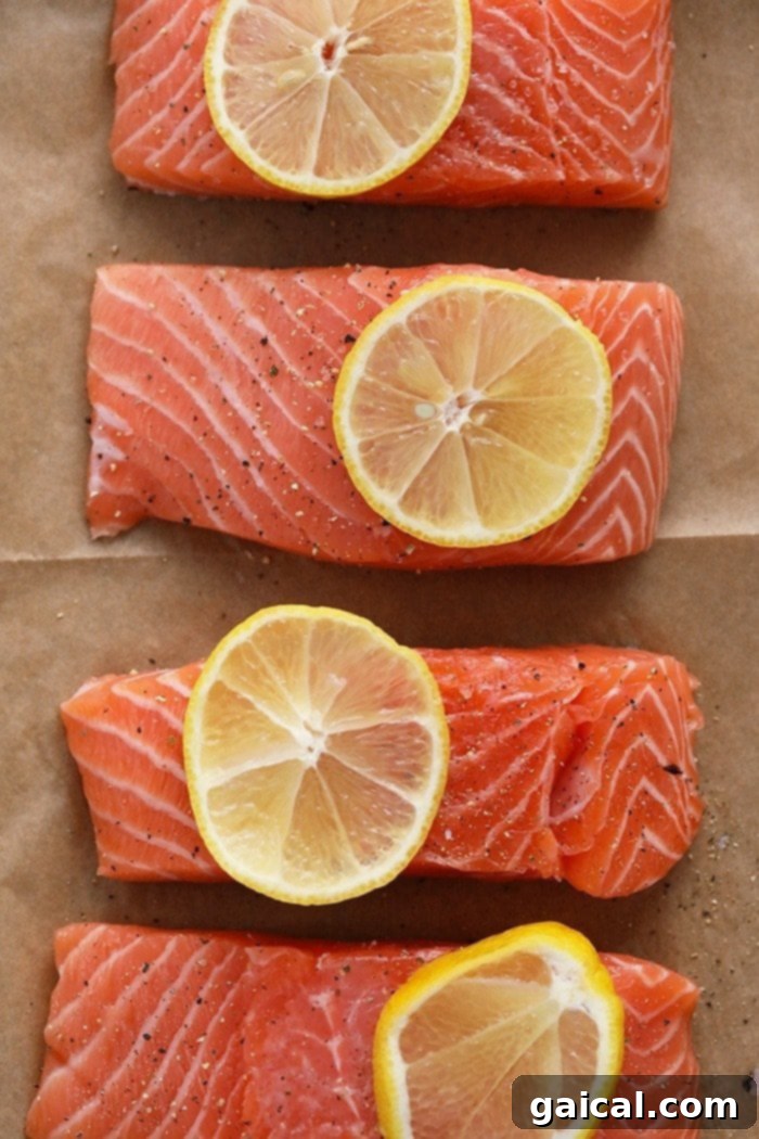 Effortless Mediterranean Salmon Meals 3 Two perfectly seasoned salmon fillets with vibrant lemon slices on top, ready to be broiled for a healthy meal