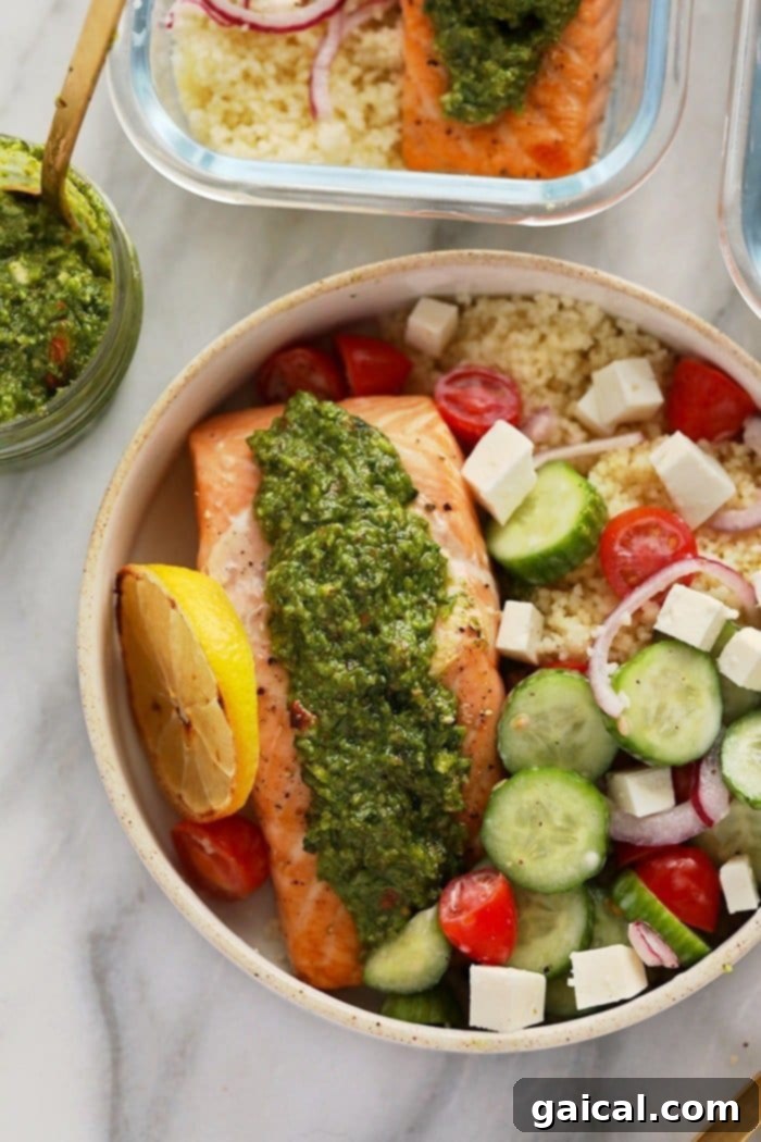 Effortless Mediterranean Salmon Meals 5 A perfectly portioned Mediterranean Salmon Meal Prep container featuring a glistening salmon fillet, a colorful Greek salad with feta, and a generous serving of fluffy couscous