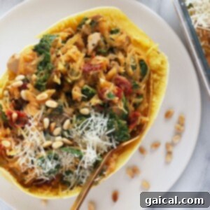 Instant Pot spaghetti squash boats with spinach and pine nuts on a white plate.