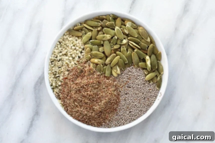 A close-up shot of various healthy seeds, including chia, flax, and hemp seeds, arranged on a plate.