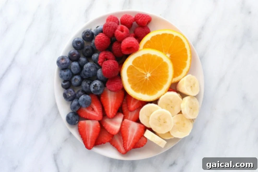 A colorful plate showcasing a variety of fresh, high-protein fruits like guava, avocado, kiwi, and blackberries.