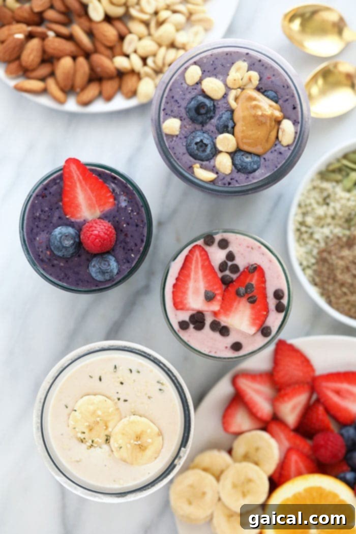 Three perfectly blended protein shakes in glass cups, garnished and ready to be enjoyed on a kitchen counter.