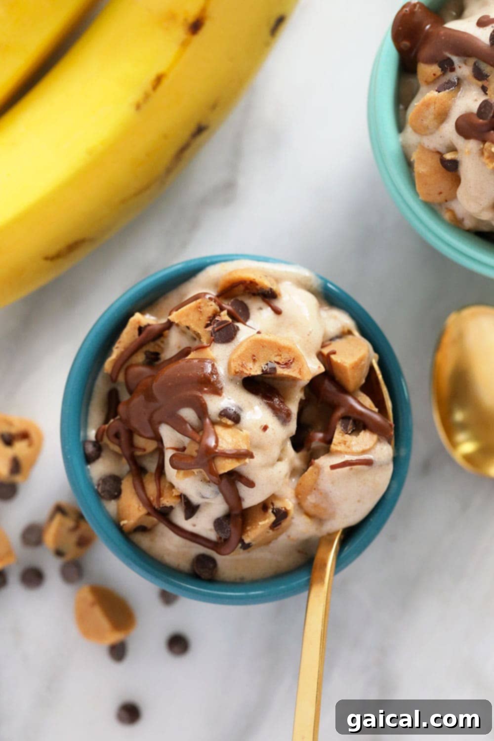 Cookie Dough Banana Bliss 6 Three bowls of vegan cookie dough banana nice cream, each topped with a generous amount of edible cookie dough chunks and a rich chocolate drizzle, appealingly arranged.