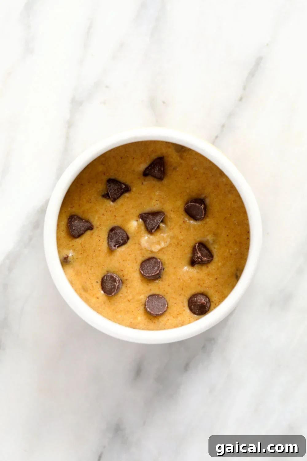 Mixing banana mug cake batter in a mug with a fork, showing the combination of wet and dry ingredients.