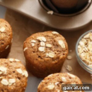 Classic Oatmeal Muffins - A Perfect Healthy Snack or Breakfast! Close-up of freshly baked Classic Oatmeal Muffins, golden brown and perfectly textured with a sprinkle of rolled oats on top. Presented beautifully.