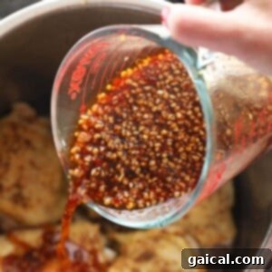 Pouring the homemade honey garlic sauce over seared chicken thighs in the Instant Pot.
