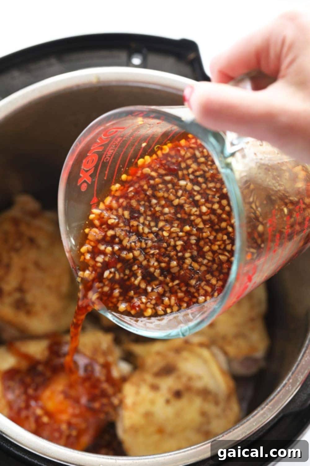 Homemade honey garlic sauce for the Instant Pot chicken. Homemade honey garlic sauce being whisked in a glass jar, ready for Instant Pot chicken thighs.