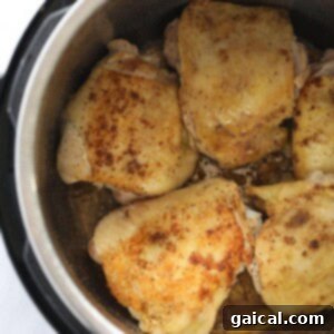 Seared chicken thighs achieving a golden-brown color in the Instant Pot.