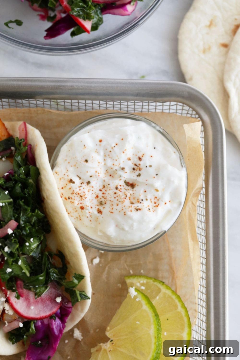 Homemade Crema for Fish Tacos A dish of creamy, zesty sauce, perfect for topping fish tacos, with fresh herbs.