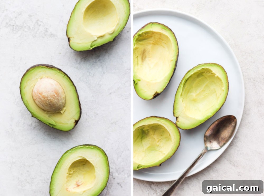 Scooped-out avocado halves perfectly arranged in a baking pan, ready for the eggs.