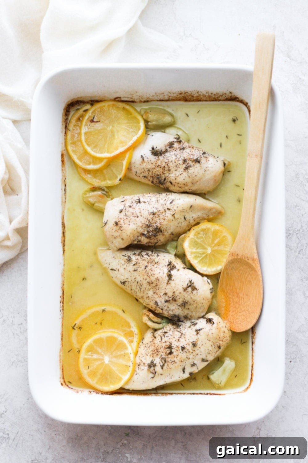 Baked lemon chicken breasts beautifully arranged in a casserole dish.