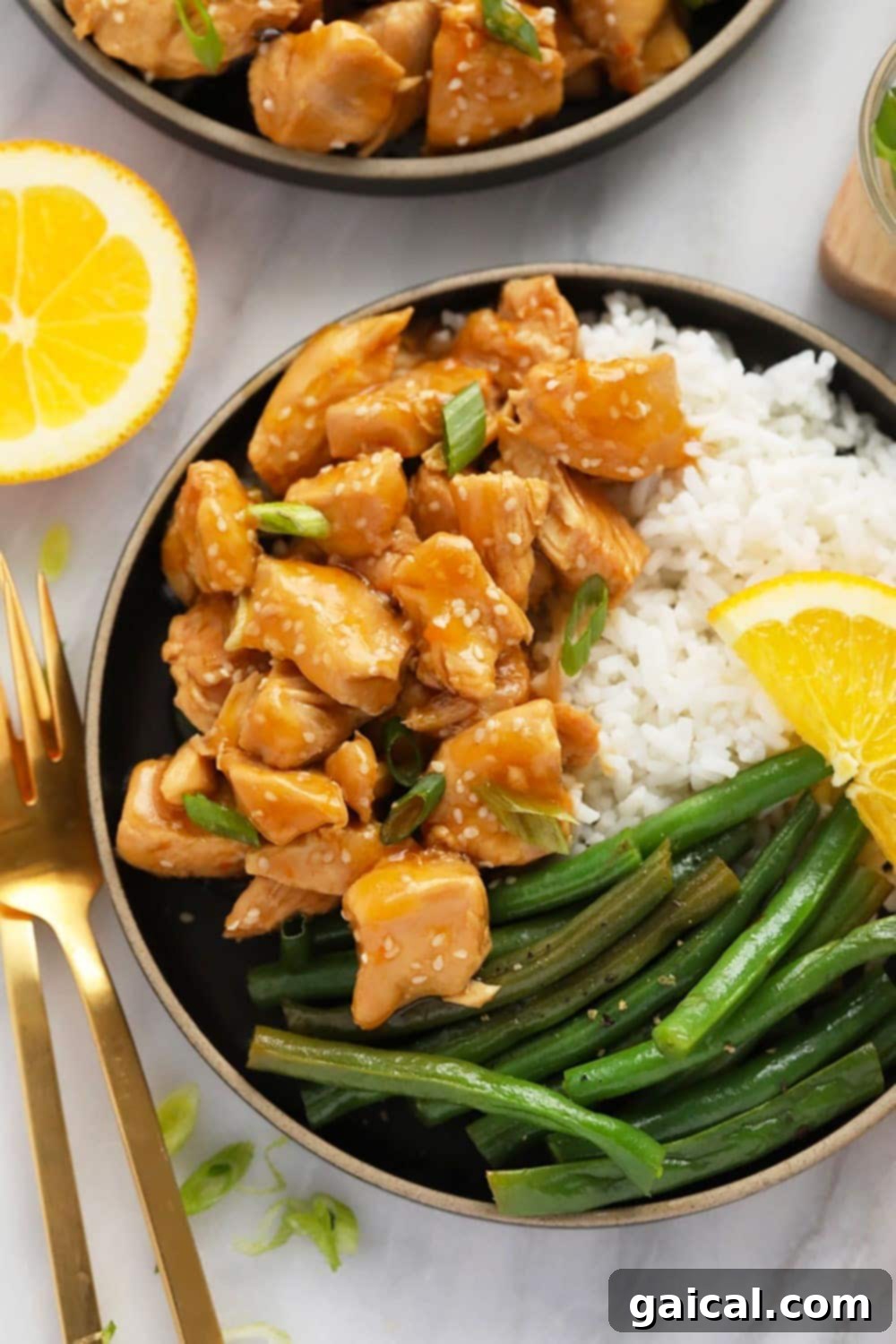 A beautifully plated dish of Instant Pot Orange Chicken with white rice and green beans.