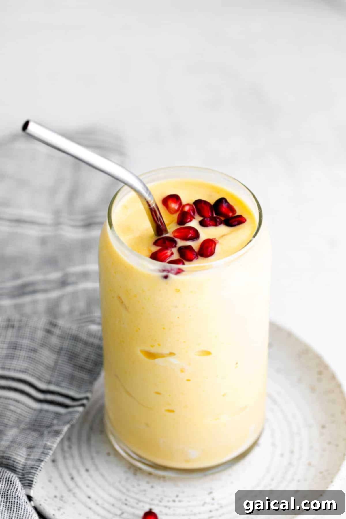Tropical Mango Bliss 2 A vibrant, creamy mango smoothie served in a clear glass, invitingly placed for enjoyment.