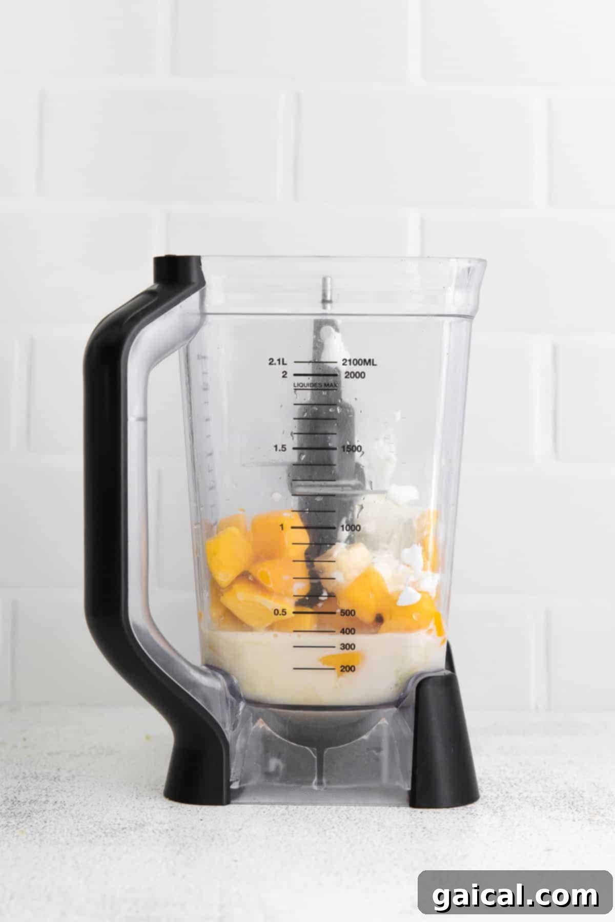 Tropical Mango Bliss 4 All the frozen fruit and liquid ingredients loaded into a high-speed blender, ready to be transformed into a creamy smoothie.