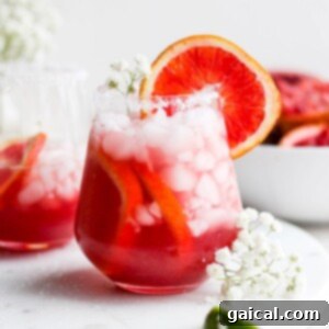 Two glasses of Blood Orange Margarita on a white plate.