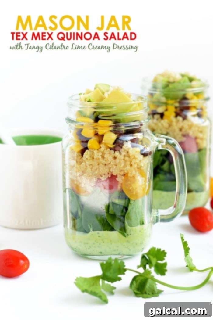 Tex-Mex Quinoa Power Jar 2 A mason jar salad with dressing on the bottom and layers of ingredients including quinoa, black beans, corn, and spinach on top.