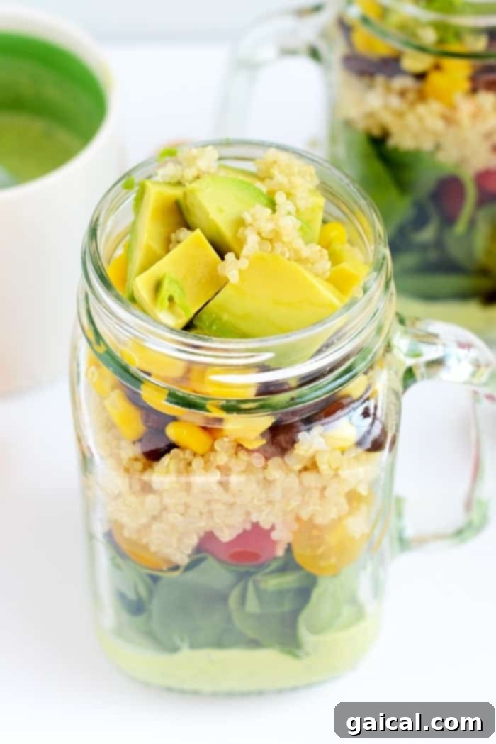 Tex-Mex Quinoa Power Jar 6 A Tex Mex Mason Jar Salad with avocado slices on top, next to a small bowl of tortilla chips.
