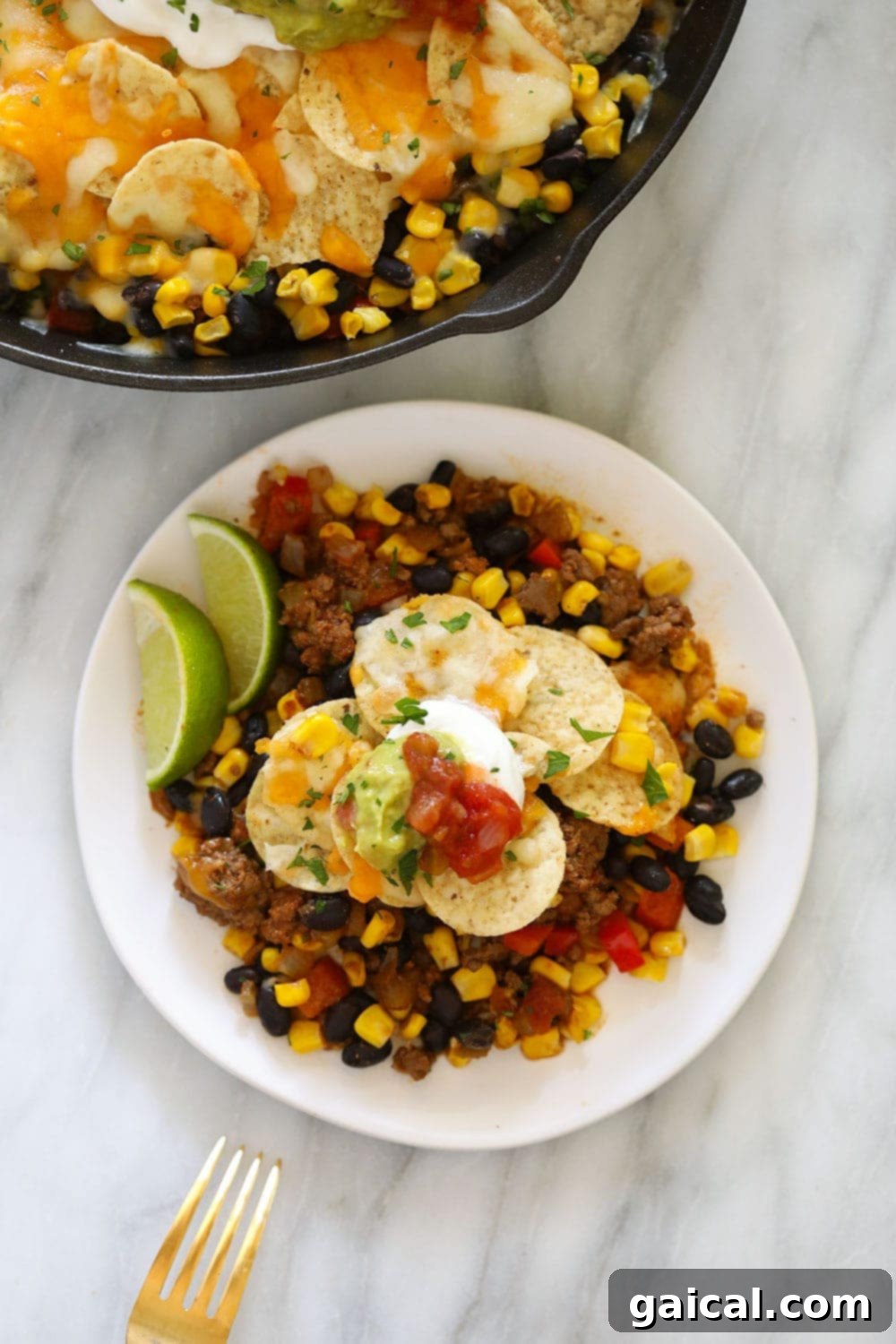 Simple Weeknight Taco Bake 5 A serving of easy taco casserole topped with Greek yogurt and guacamole on a plate.