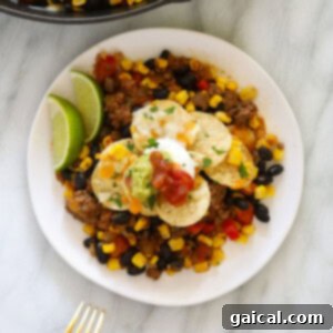Easy taco casserole ready to be served on a plate with toppings.