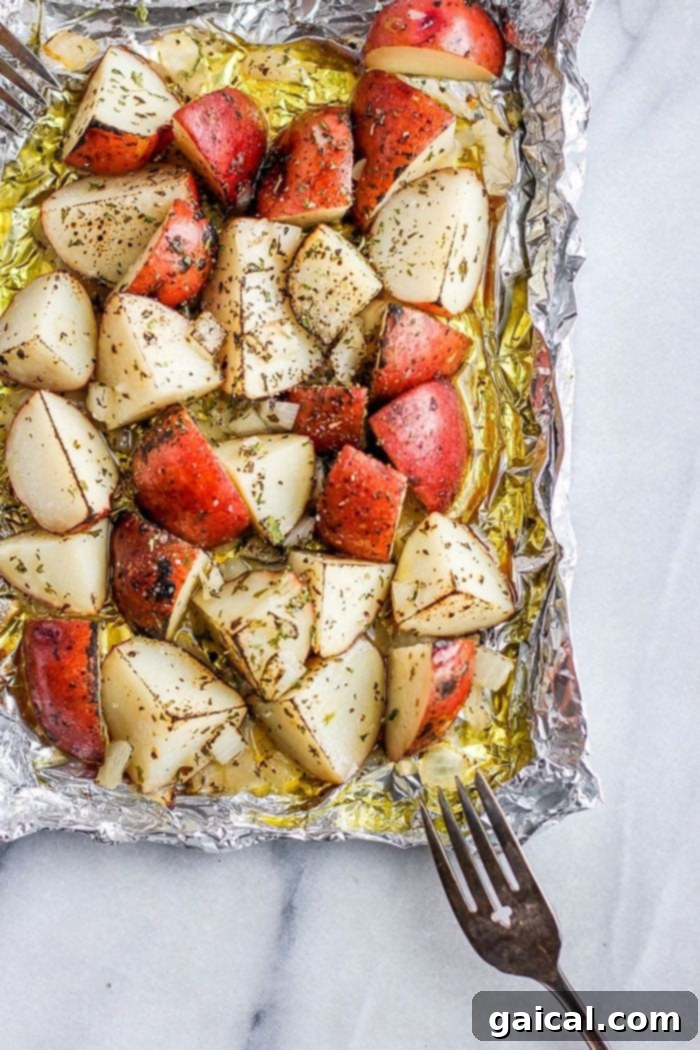 Red potatoes on tin foil covered in olive oil and spices, ready for cooking