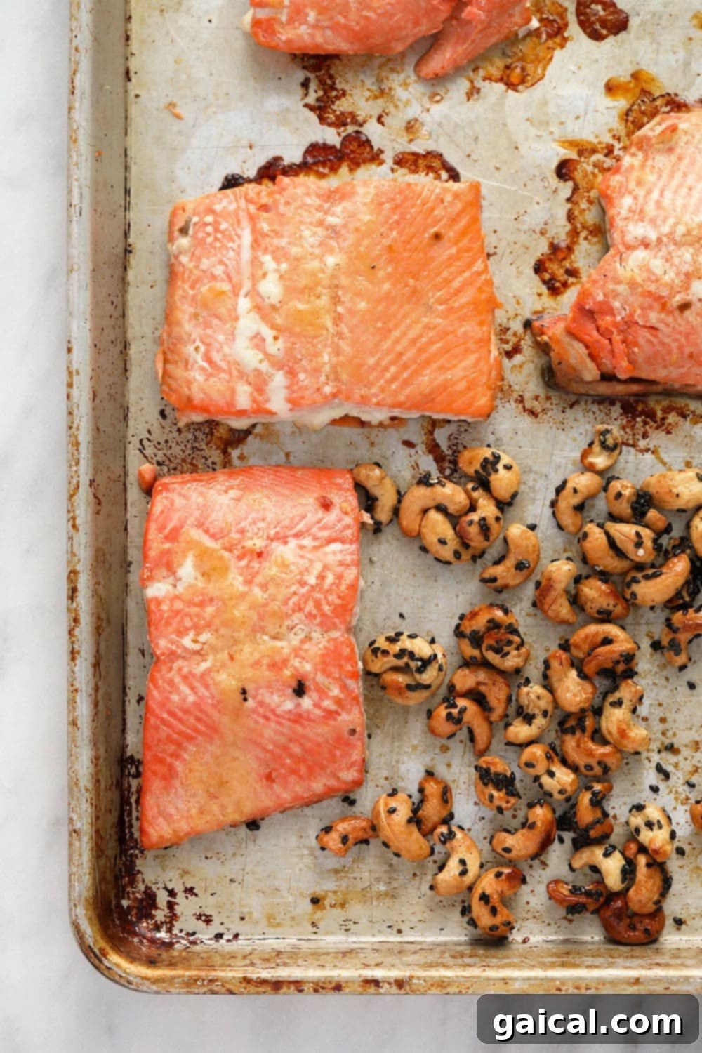 Marinated salmon and maple sesame cashews baking on a single sheet pan